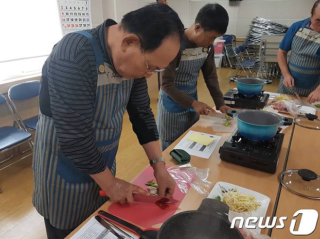 5일 서울 종로구 창신2동주민센터에서 열린 '소금 빼고 건강 더하기' 프로그램에 참여한 한 중년 남성이 요리를 배우고 있다.(서울 종로구청 창신2동 주민센터 제공)© News1