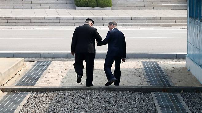 문재인 대통령과 북한 김정은 국무위원장이 지난 4월 27일오전 판문점 군사분계선에서 만나 인사한 후 함께 북측으로 넘어가고 있다. 두 정상은 바로 남측으로 넘어와 환영식장으로 이동했다. [중앙포토]
