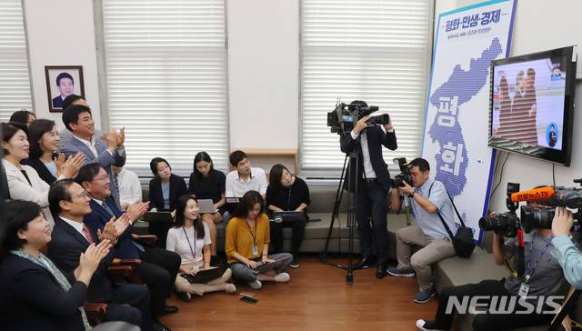【서울=뉴시스】이종철 기자  = 18일 오전 서울 여의도 국회에서 열린 더불어민주당 원내대책회의에 앞서 홍영표 원내대표를 비롯한 의원들이 남북정상회담을 위해 평양 순안공항에 도착한 문재인 대통령이 김정은 위원장을 만나는 모습을 방송으로 시청하고 있다. 2018.09.18.jc4321@newsis.com