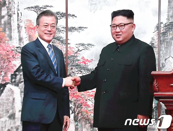 문재인 대통령과 김정은 북한 국무위원장이 19일 평양 백화원 영빈관에서 남북정상 공동 기자회견을 마치고 악수하는 모습이 서울 동대문 디자인플라자 평양남북정상회담 프레스센터에 생중계 되고 있다.2018.9.19/뉴스1 © News1 송원영 기자