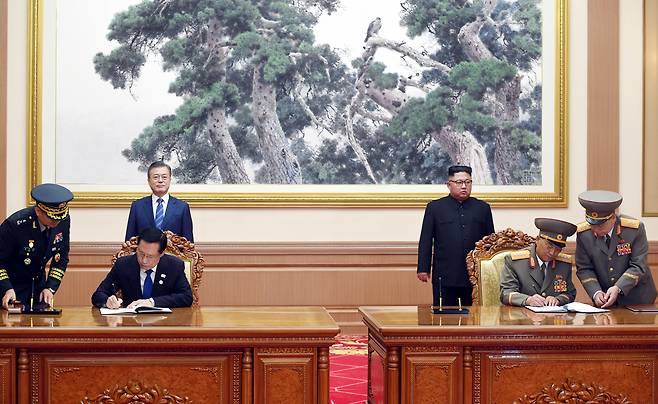 문재인 대통령과 김정은 국무위원장이 임석한 가운데 송영무 국방부 장관과 로광철 인민무력상이 군사 분야 합의서에 서명하고 있다.평양사진공동취재단