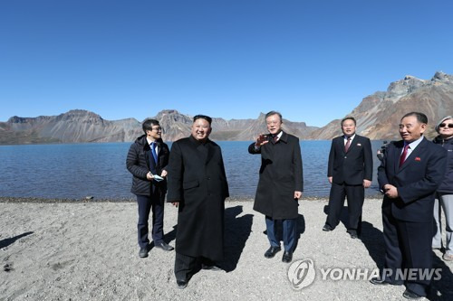 [평양정상회담]천지에 오른 남북정상 (평양=연합뉴스) 평양사진공동취재단 배재만 기자 = 문재인 대통령과 북한 김정은 국무위원장이 20일 오전 백두산 천지에 서서 대화하고 있다.  2018.9.20       scoop@yna.co.kr  (끝)