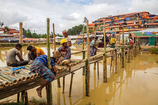 ⓒ장준희 난민들이 홍수에 대비해 대나무로 만든 다리를 보수하고 있다