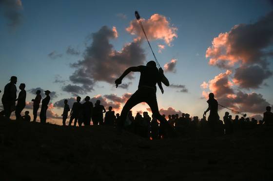 중력 새총 효과는 주변 행성이나 블랙홀에서 추진력을 얻어 비행하는 방법으로 육상종목 해머던지기에서 해머를 빙빙 돌린 후, 원심력을 높여 던지는 것과 유사하다. 사진은 지난 14일, 팔레스타인 시위대가 이스라엘 군에 돌을 던지기 위해 새총을 사용하는 모습. [신화통신]