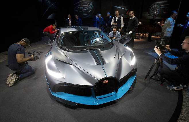 슈퍼카를 뛰어넘는 하이퍼카답게 부가티 디보의 가격은 우리 돈으로 65억에 이른다. 최고 시속은 385km에 제한되어 있다. 지난1일 파리모터쇼 미디어데이에서 취재진들이 차량을 살펴보고 있다.[AP=연합뉴스]