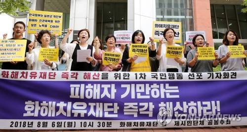 화해치유재단 해산하라! (서울=연합뉴스) 이재희 기자 = 6일 오전 서울 중구 화해치유재단 앞에서 정의기억연대 등 시민단체 회원들이 재단 해산을 촉구하는 구호를 외치고 있다. 2018.8.6 scape@yna.co.kr (끝)