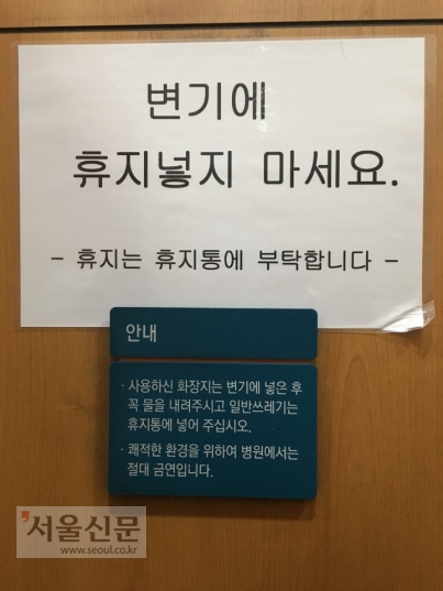 지난 9일 서울의 한 대형 병원 화장실에 써붙여진 안내문. A4 용지에는 “변기에 휴지넣지 마세요”라고 써있고, 바로 아래 안내문에는 “사용하신 화장지는 변기에 넣은 후 꼭 물을 내려달라”고 적혀 있다.독자 제공