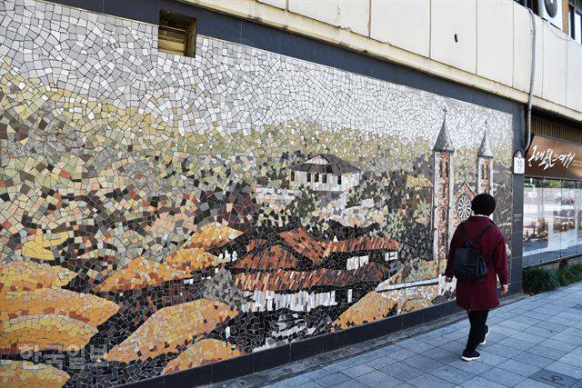 계산성당 인근 담벼락의 모자이크. 초가집만 있는 마을에 성당 건물만 우뚝하다.