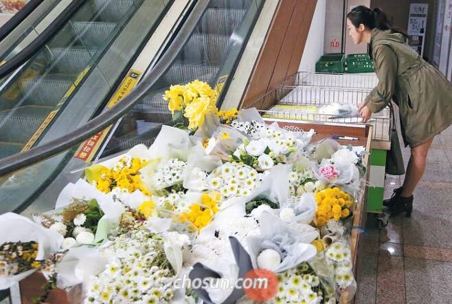 22일 오후 서울 강서구 PC방 살인 사건 현장에 마련된 추모 공간에서 한 시민이 피해자 신모(21)씨를 추모하며 헌화하고 있다. /오종찬 기자