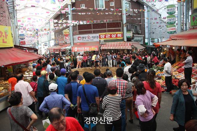 시장 상인들과 손님간 펼쳐진 씨름 대결. 씨름은 별다른 기술없이도 즐길 수 있는 놀이이다.|문화재청 제공