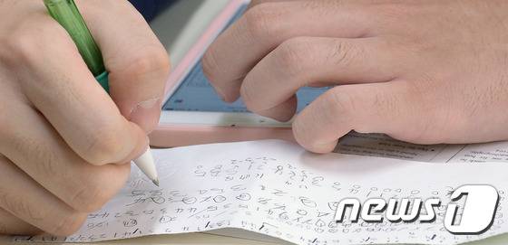 지난해 '2017학년도 대학수학능력평가'를 마친 학생이 자신이 시험 중 적어온 답을 보고 가채점을 하고 있다. /사진제공= 뉴스1