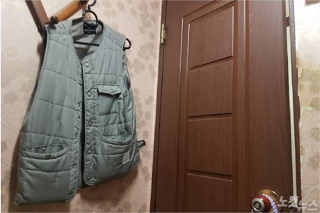 한씨의 고시원 방. 언제 불이 날까 두려운 마음에 지갑을 넣어둔 조끼를 방문 옆에 걸어놨다.