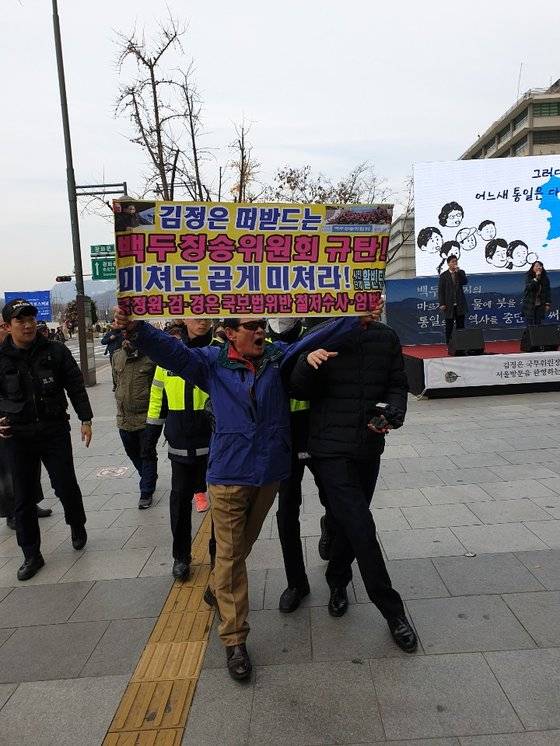 홍정식 활빈단 대표가 18일 백두칭송위원회의 연설대회 '김정은' 시작 전 행사 중단을 요구하며 항의시위를 하고 있다. 김다영 기자