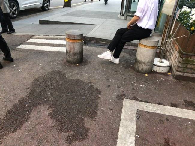 Spit marks and cigarette butts stain a street in Seoul. (Jo He-rim/The Korea Herald)