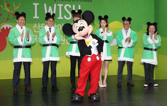 28일 오전 서울시민청에서 열린 '2018 산타원정대' 크리스마스 선물포장 행사에서 한국에 첫방문한 미키마우스와 배우 이준기, 신세경을 비롯한 참석자들이 시민들에게 인사를 하고 있다. 우상조 기자