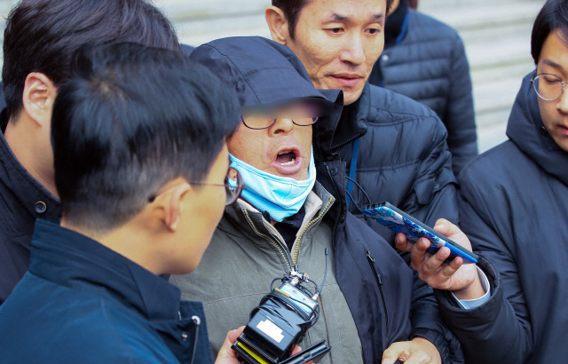 김명수 대법원장 출근 승용차에 화염병을 던진 농민 남 모(74)씨가 29일 서울 서초구 서초경찰서에서 영장실질심사를 위해 나서던 중 항변하고 있다./연합뉴스