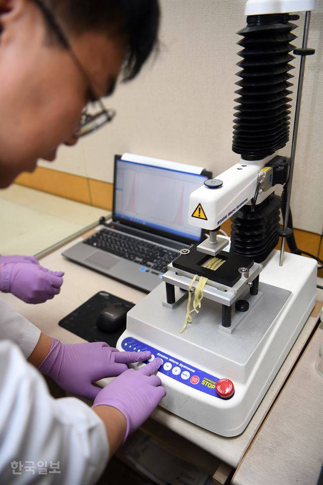 서울 동작구 농심 본사에 있는 연구소에서 한 연구원이 삶은 라면을 물성분석기에 올려놓고 있다. 물성분석기는 면의 강도와 탄성 등을 물리적으로 측정하는 기기다. 신상순 선임기자