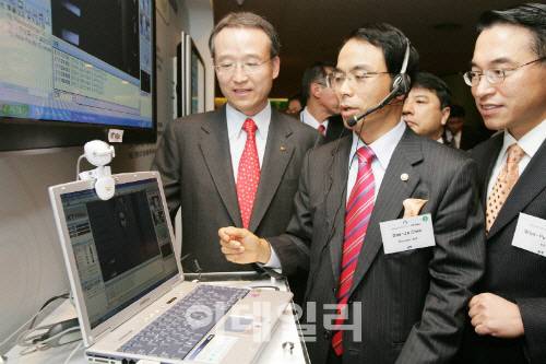 2005년 11월15일 진대제 당시 정보통신부 장관(가운데, 현 한국블록체인협회 회장)이 부산 파라다이스호텔에서 KT가 개최한 ‘APEC 와이브로 시연 개통식’에서 당시 KT 남중수 사장(왼쪽, 대림대총장), 홍원표 당시 KT휴대인터넷사업본부장(현 삼성SDS사장)과 와이브로를 시연해 보고 있다. 정통부 제공