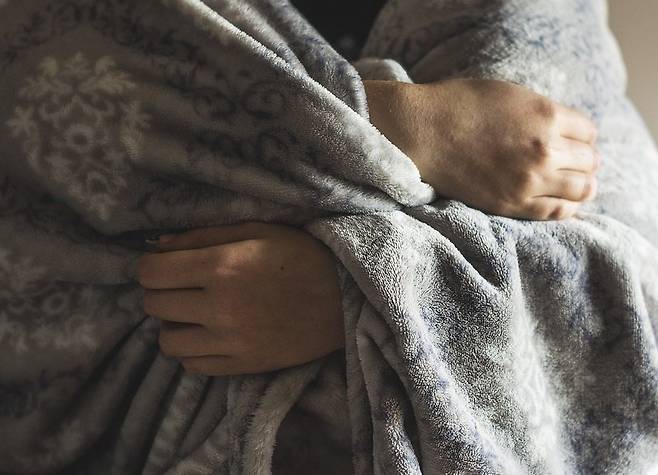 비행기 실내에선 추위를 느껴 담요로 온 몸을 감싸는 승객을 흔히 볼 수 있다. [블로그 캡처]