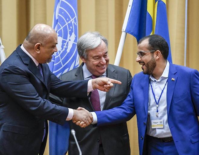 스웨덴 림보에서 13일(현지시간) 유엔 중재로 열린 예멘 평화 협상이 끝난 뒤 정부 측 대표인 칼레드 알야마니 예멘 외무장관(왼쪽)과 후티 반군 측 대표인 무함마드 압델살람(오른쪽)이 악수를 나누는 모습을 안토니우 구테흐스 유엔 사무총장이 웃으며 지켜보고 있다. AP연합뉴스
