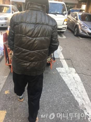 손수레를 끌고 가는 최진철씨(55) 오른편 도로로 흰색 트럭이 지나가려 하고 있다. 좁다란 도로라 피할 공간이 별로 없었다. 그래서 늘상 안전 위험에 노출돼 있다. 최씨도 오토바이 사고로, 허리뼈가 부러졌다고 했다./사진=남형도 기자