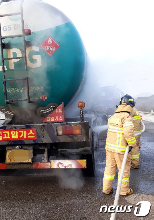 소방대원들이 19일 오전 전남 강진군 남해고속도로 영암방향 강진4터널 부근에서 LPG 20톤을 싣고 달리다가 바퀴에 불이 난 탱크로리의 열기를 식히고 있다. 연기는 30여분 만에 꺼졌으며, 폭발이나 가스 유출 등의 피해로 이어지지 않았다.(전남 강진소방서 제공)2018.12.19/뉴스1