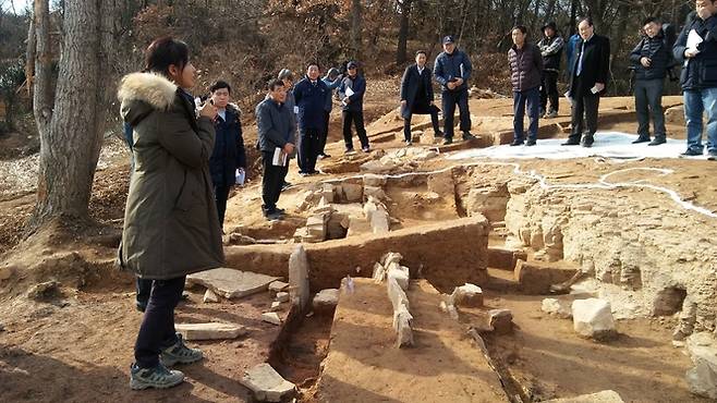 함안군 아라가야 왕성추정 유적의 10호 건물터에서 조사단원이 바로 앞의 부뚜막 흔적을 설명하고 있다.