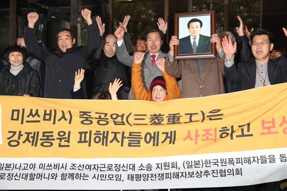 지난해 11월 29일 대법원이 미쓰비시를 상대로 한 강제징용 피해자들의 손해배상 청구 소송에서 원고 승소 판결을 내리자, 조선여자근로정신대 피해자인 김성주 할머니(앞줄 가운데)를 비롯한 징용 피해자들 대법정 앞에서 손을 들며 환호하고 있다. [중앙DB]