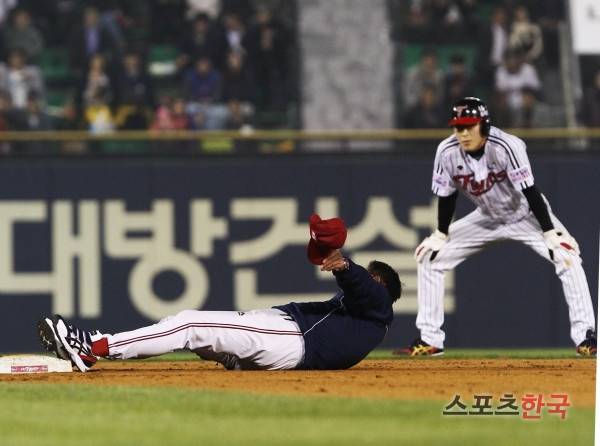 판정에 대한 항의 차원으로 2루 베이스 옆에 눕고 있는 김기태 감독과 이를 지켜보는 문선재. 스포츠코리아 제공