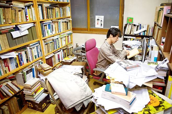 2013년 10월 후지이 다케시 당시 역사문제연구소 연구실장이 사무실 책과 서류 더미 사이에서 책을 읽고 있다. 박승화 기자 eyeshoot@hani.co.kr