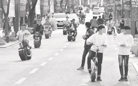 전주한옥마을에서 전동킥보드와 전동스쿠터를 탄 10대들이 왕복 2차선 도로 한복판을 질주하고 있다. [프리랜서 장정필]
