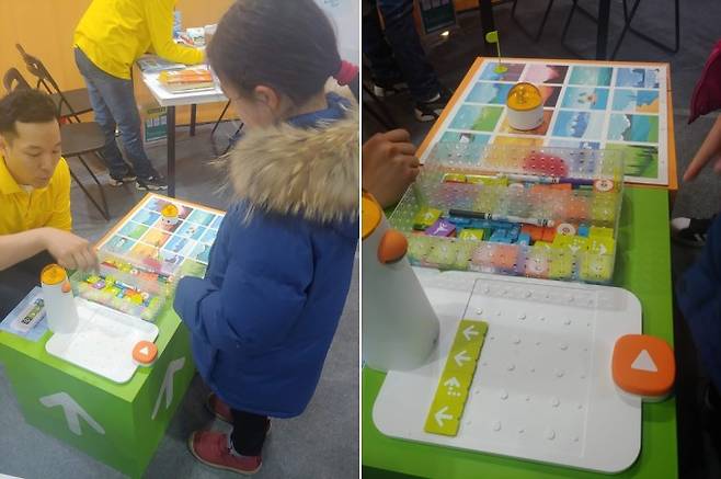 <캡션2> 8일부터 10일까지 서울 강남구 SETEC에서 열린 ′2019 초등교육 박람회′에서 아이가 피지컬 코딩 교구에 대한 소개를 듣고 있다. 로봇이 목적지에 도착하도록 전진 및 후진, 좌우 회전 명령을 순서대로 조합하는 방식으로 코딩이 이뤄진다. 단순한 명령과 직관적인 아이콘 블록은 컴퓨터와 대화를 쉽게 만들지만, 할만한 게 별로 없어 보이는 것도 사실이다.