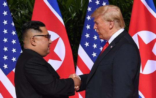 작년 6월12일 싱가포르에서 열린 북-미 정상회담에서 김정은 북한 국무위원장과 도널드 트럼프 미국 대통령이 악수하고 있다. <연합 제공>