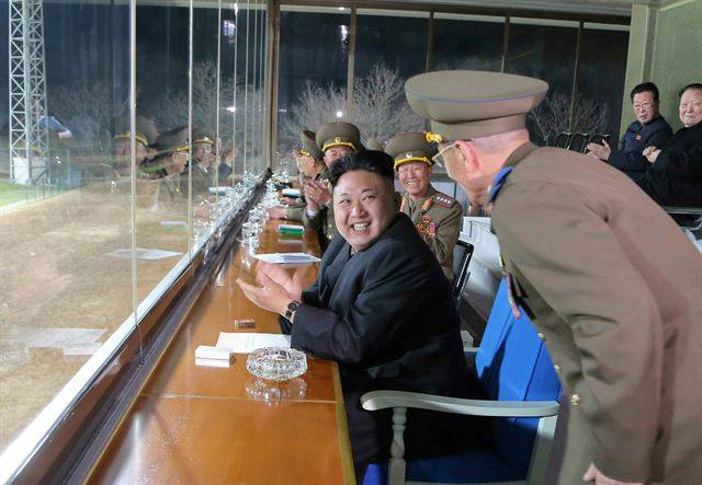 김정은 북한 국무위원장이 군인들과 함께 2014년 4월 축구 경기를 관람하는 모습. 흰 담뱃갑이 상 위에 놓여있다. 노동신문 연합뉴스