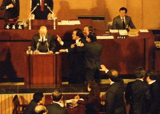 1989년 12월 31일 전두환 前대통령이 광주사태와 관련 계엄사의 지위권 발돌문제를 언급하자 특위 위원이 아니 평민당의 이철용의원이 방청석에서 단상으로 뛰어나와 전씨에게 삿대질을 하며 "살인마"라고 고함치고 있다. [중앙포토]