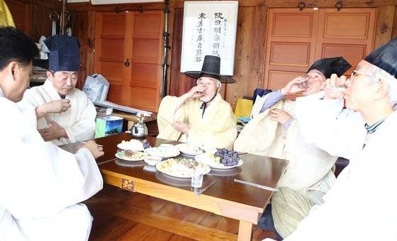 추석인 24일 경북 칠곡군 귀암 문익공 이원정(李元禎) 종택 13대 종손 이필주((75·가운데)씨가 추석 차례를 지내고 제관들과 음복하고 있다. [뉴스1]