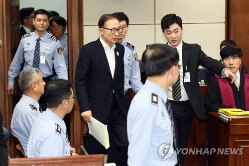 법정 들어오는 이명박 전 대통령 (서울=연합뉴스) 한상균 기자 = 뇌물수수와 다스 횡령 등 혐의로 구속기소 된 이명박 전 대통령이 23일 오후 서울중앙지법에서 열린 첫 공판에 출석하기 위해 법정으로 들어서고 있다.  2018.5.23 xyz@yna.co.kr