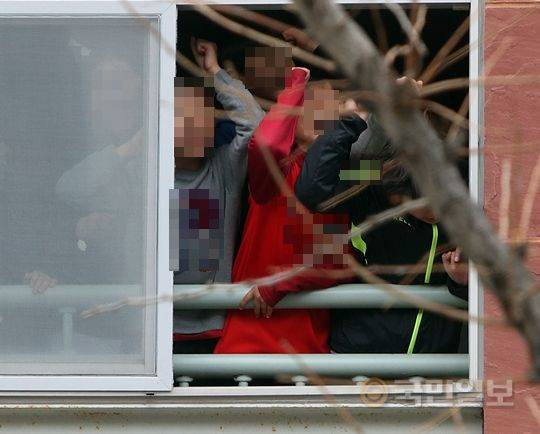 전두환 전 대통령이 광주지법으로 출두한 11일 낮 12시30분쯤 법원 맞은편 동산초등학교 학생들이 창가에서 구경하고 있다. 광주=최현규 기자