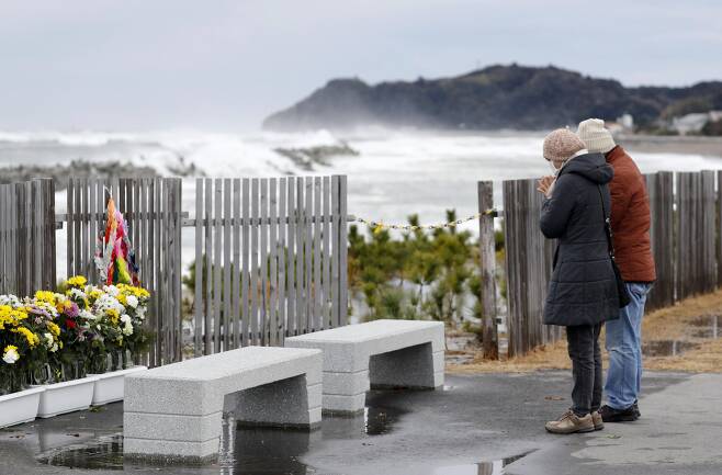 11일 일본 후쿠시마현 인근 바닷가에서 한 일본인 부부가 희생자들을 기리며 기도를 하고 있다. [AP=연합뉴스]
