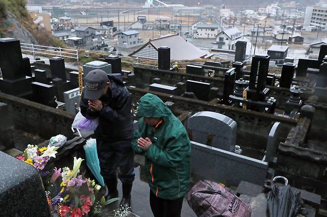 10일 일본 이와테현 오쓰시시의 묘지에서 시민들이 희생자를 기리며 기도를 하고 있다. [지지통신]