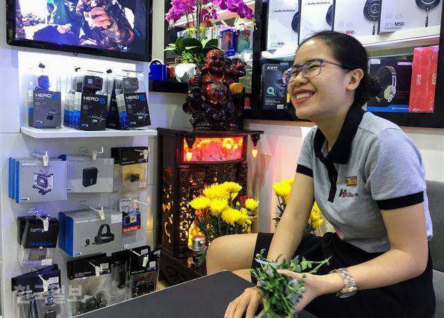 호찌민 시내 한 휴대폰 매장 직원이 매장 안에 설치된 신주를 장식하고 있던 꽃을 바꾸고 있다. 돈을 관장하는 신을 모시고 있으며 1주일에 한번씩 교체한다고 한다. 토속신앙은 베트남 사람들의 생활 전반에 광범하게 영향을 미치고 있다.호찌민=정민승 특파원