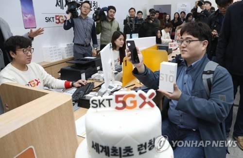 SK텔레콤 세계최초 5G 개통 (서울=연합뉴스) 정하종 기자 = 5일 오전 서울 SK텔레콤 강남직영점에서 '갤럭시 S10 5G' 일반인 첫 개통자인 이유건 씨가 휴대전화를 받고 웃음을 짓고 있다. 2019.4.5 chc@yna.co.kr