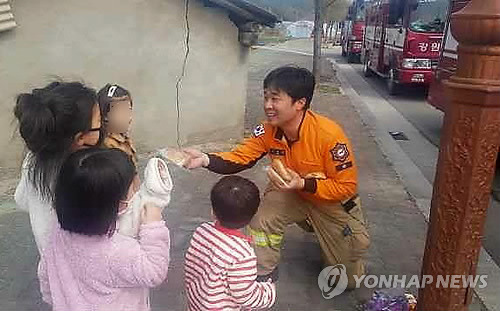 "소방관 아저씨, 과자 드시고 힘내세요" (강릉=연합뉴스) 강원산불 사흘째인 6일 강릉시 옥계면 옥계119안전센터 인근에서 어린아이들이 소방대원에게 찾아와 과자를 건네자 소방대원이 진화작업을 하면서 먹으려고 챙긴 빵을 아이들에게 나눠주고 있다. 2019.4.6 [강원도소방본부 제공] conanys@yna.co.kr