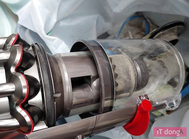 빨간색 레버를 밀면 먼지통 뚜껑이 자동으로 열린다