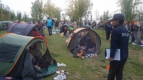 여의도 한강공원 텐트 단속 (서울=연합뉴스) 고현실 기자 = 27일 오후 여의도 한강공원에서 단속원이 설치 허용 시간인 오후 7시를 지나고도 철거하지 않은 텐트들을 단속하고 있다. 2019.4.28 okko@yna.co.kr