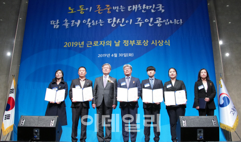 이재갑 고용노동부 장관(왼쪽에서 세번째)이 30일 서울 양재동 엘타워에서 열린 2019 근로자의 날 유공 정부포상 시상식에서 수상자들과 기념사진을 찍고 있다. 고용노동부 제공.
