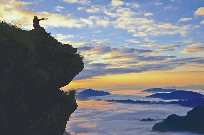 태국 치앙라이 푸치파국립공원 정상에 있는 사자바위에 앉아 일출을 지켜보고 있다. 사진 태국관광청