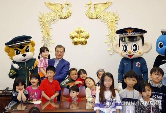문재인 대통령이 어린이날인 5일 오전 청와대 집무실에서 초청된 어린이들과 기념촬영을 하고 있다. 이날 청와대는 강원도 산불진화 소방관, 군인, 경찰 자녀와 산불 피해 초등학교 학생 및 아동정책 수혜 아동, 독립유공자 후손 등 총 180명의 어린이를 청와대로 초청해 행사를 열었다. [연합뉴스]