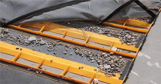 트럭에 달아서 끌고 다닌 매트에 수거된 FOD. 돌과 나뭇가지 등이 많이 보인다. [사진 인천공항공사]