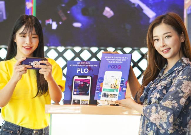SK텔레콤 홍보모델들이 POOQ과 FLO를 데이터 무제한으로 즐길 수 있는월정액 부가서비스 ‘POOQ 앤 데이터’, ‘FLO 앤 데이터’를 소개하고 있는 모습 [SKT 제공]